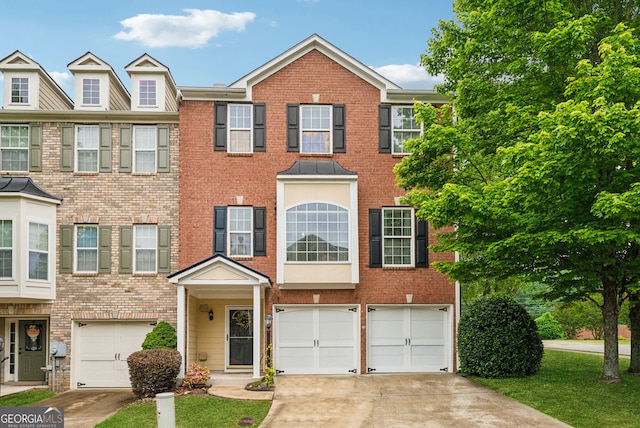 multi unit property featuring driveway, an attached garage, and brick siding