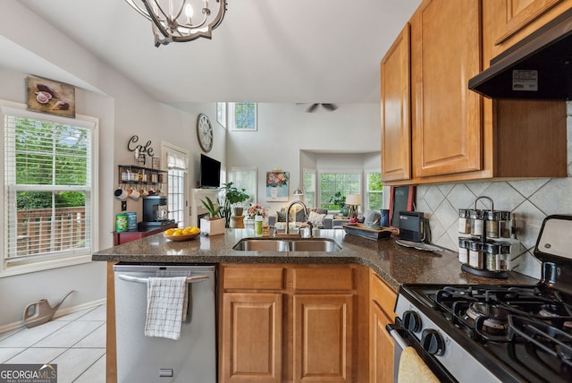 kitchen with appliances with stainless steel finishes, a sink, under cabinet range hood, a peninsula, and a chandelier