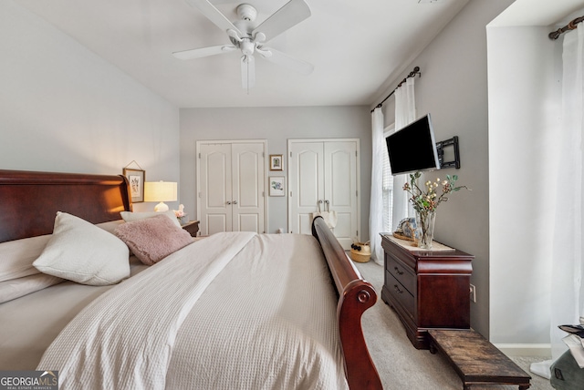 bedroom featuring multiple closets, carpet floors, and ceiling fan