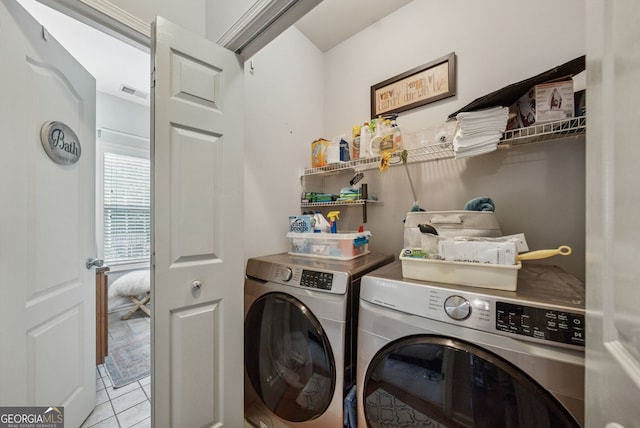 laundry room with independent washer and dryer and light tile patterned floors