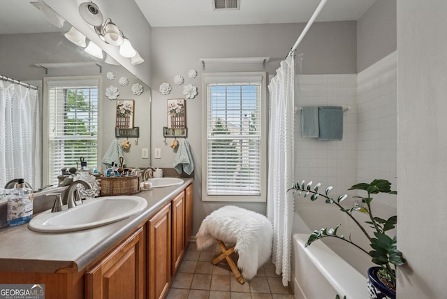 bathroom featuring tile patterned flooring, double vanity, and shower / tub combo