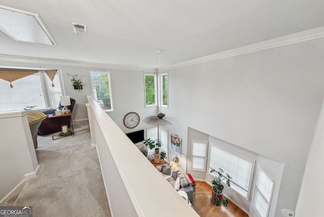 staircase featuring attic access, ornamental molding, baseboards, and a ceiling fan