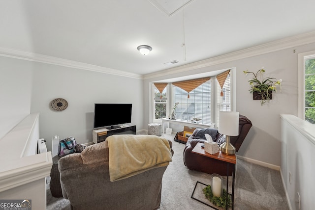 living room with crown molding, plenty of natural light, attic access, baseboards, and carpet