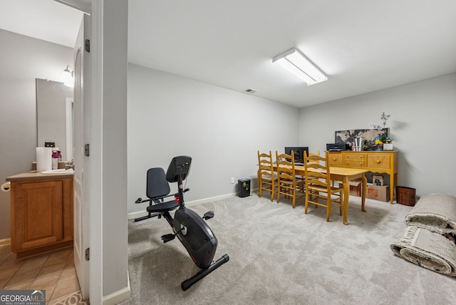 workout area featuring a sink, baseboards, and carpet flooring