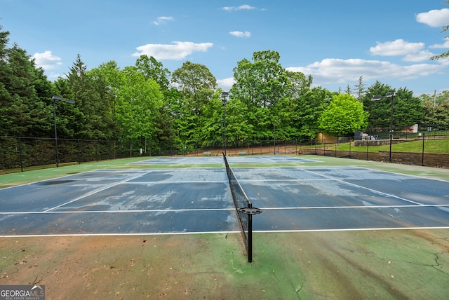 view of tennis court featuring fence