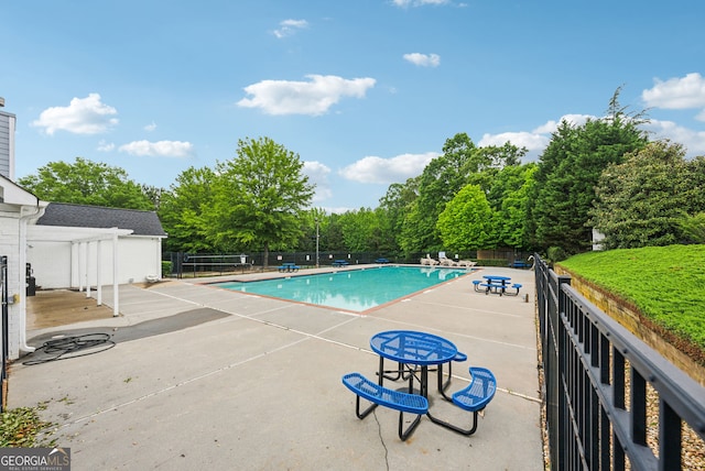 community pool with fence and a patio