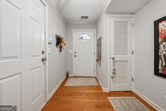 doorway to outside with light wood-style floors and baseboards