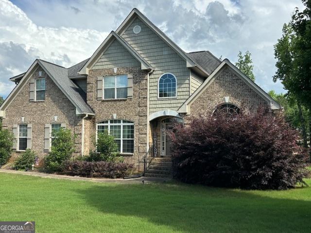 craftsman-style home featuring a front lawn and brick siding