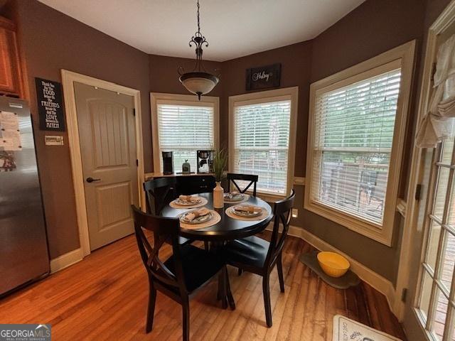 dining space featuring baseboards and light wood-type flooring