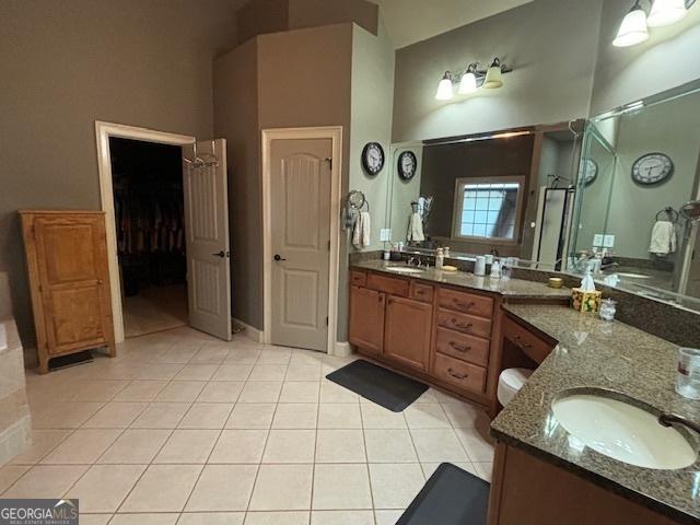 bathroom with tile patterned floors, a stall shower, vanity, and a high ceiling