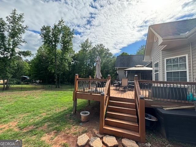 wooden deck with a lawn and outdoor dining area