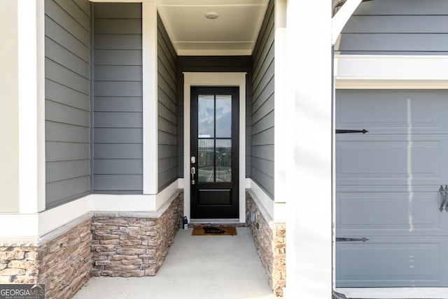 6821 Bungalow Rd, Flowery Branch, GA 30542 - view of exterior entry featuring stone siding and a garage