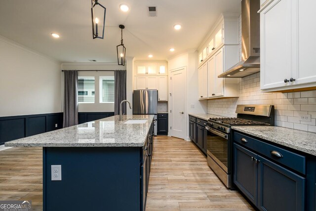 6821 Bungalow Rd, Flowery Branch, GA 30542 - kitchen with stainless steel appliances, wall chimney exhaust hood, blue cabinets, white cabinetry, and ornamental molding