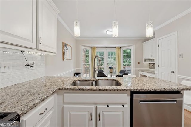kitchen featuring stainless steel appliances, a sink, ornamental molding, tasteful backsplash, and white cabinets