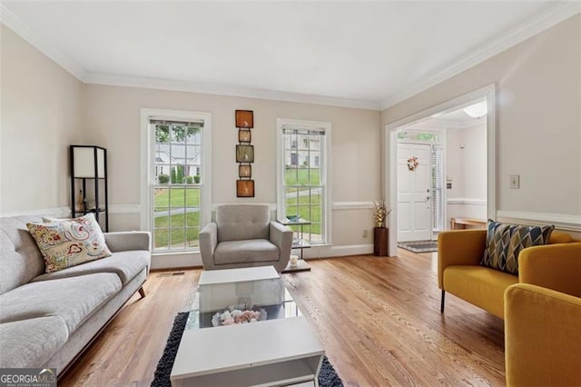 living room with ornamental molding and wood finished floors