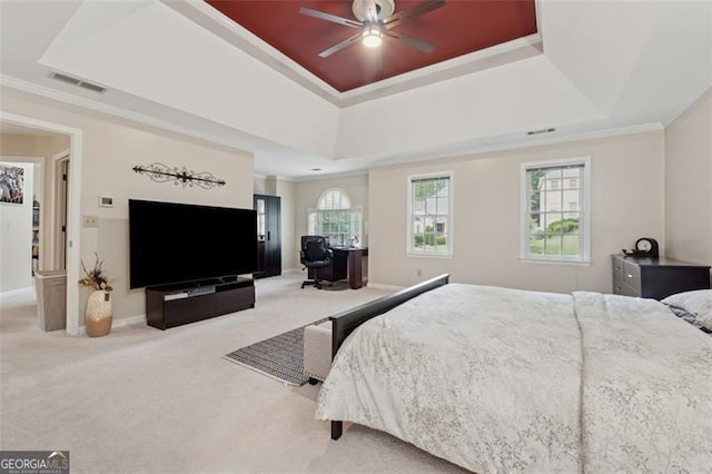 bedroom with a tray ceiling, carpet, crown molding, and baseboards