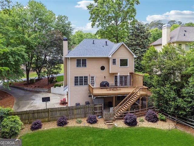 back of property with stairway, a wooden deck, and a chimney