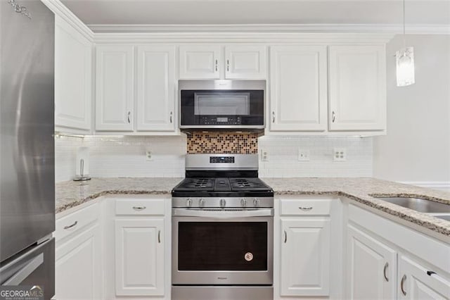 kitchen featuring appliances with stainless steel finishes, decorative backsplash, white cabinets, and light stone countertops