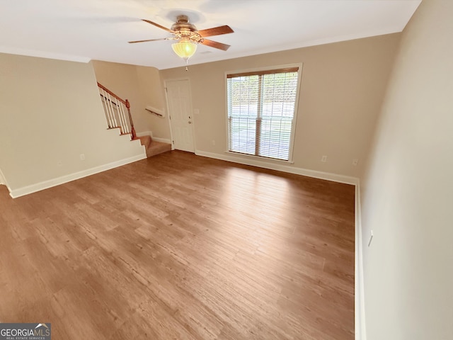 445 Logmont Trce, Athens, GA 30606 - unfurnished living room with stairs, a ceiling fan, light wood-style flooring, baseboards, and ornamental molding