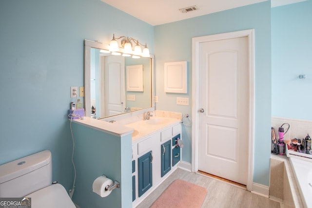 4 E Moore St, Statesboro, GA 30458 - full bathroom with wood finished floors, tiled tub, toilet, and vanity