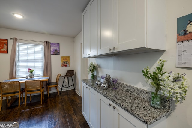 6 Oleander Ave, Savannah, GA 31404 - kitchen with dark wood-type flooring, stone counters, white cabinets, and baseboards