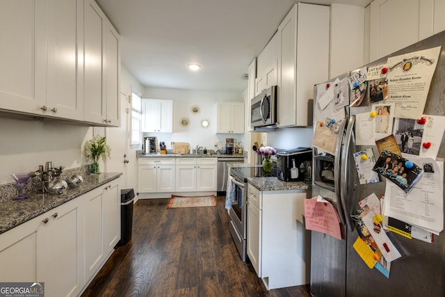 6 Oleander Ave, Savannah, GA 31404 - kitchen featuring stainless steel appliances, dark wood finished floors, dark stone counters, white cabinets, and a sink