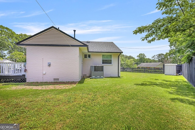 back of house with brick siding, roof with shingles, a wooden deck, and crawl space