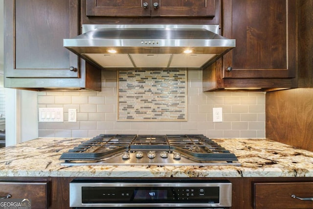 kitchen featuring wall oven, stainless steel gas cooktop, exhaust hood, and dark brown cabinets