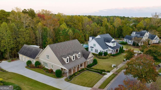 aerial view of property and surrounding area with a heavily wooded area