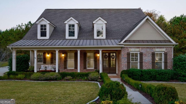 view of front of property with french doors, brick siding, and a standing seam roof