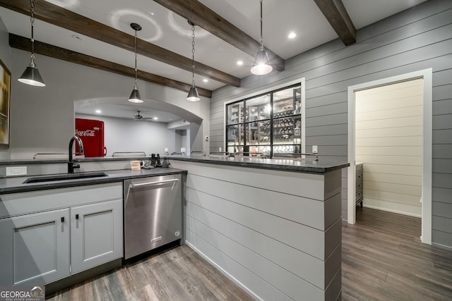 1849 Rock Springs Ln NE, Atlanta, GA 30324 - kitchen featuring dishwasher, a sink, wood walls, dark countertops, and dark wood finished floors