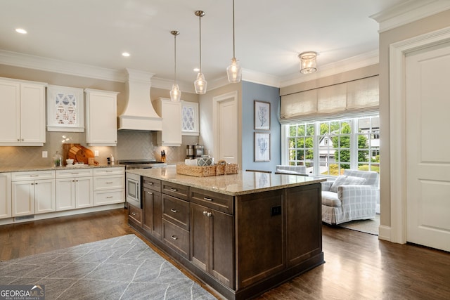 1849 Rock Springs Ln NE, Atlanta, GA 30324 - kitchen with premium range hood, white cabinetry, dark brown cabinetry, dark wood-style floors, and tasteful backsplash