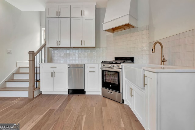 126 Morgan St, Senoia, GA 30276 - kitchen with stainless steel appliances, custom range hood, light countertops, and white cabinets
