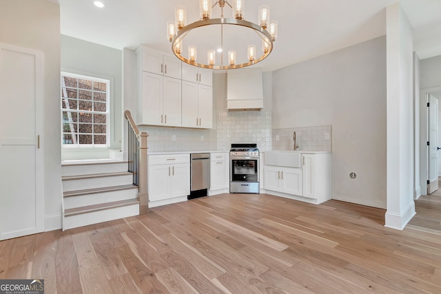 126 Morgan St, Senoia, GA 30276 - kitchen with stainless steel appliances, a sink, a chandelier, backsplash, and light wood-type flooring