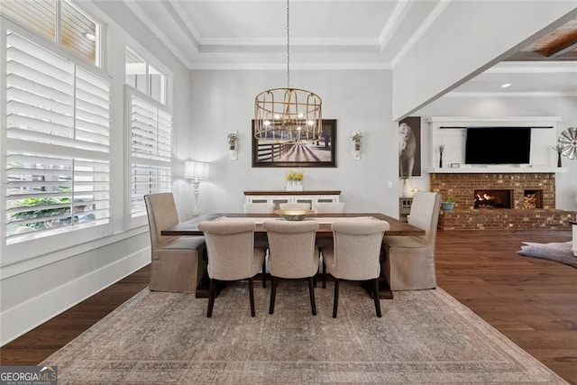 116 Serenity Lake Dr, Alpharetta, GA 30004 - dining room with wood finished floors, a brick fireplace, a chandelier, a tray ceiling, and ornamental molding