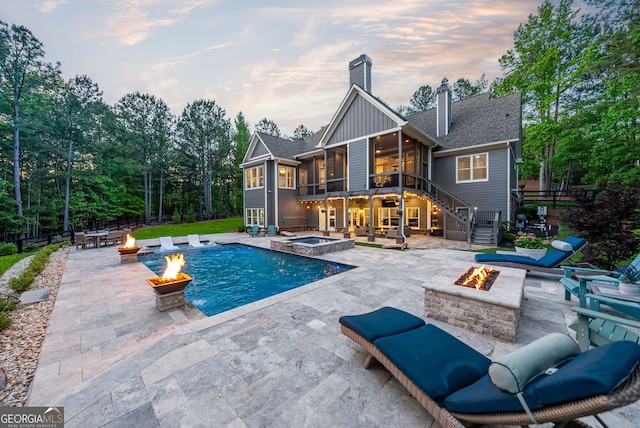 116 Serenity Lake Dr, Alpharetta, GA 30004 - back of house featuring a fire pit, a sunroom, a patio, stairway, and board and batten siding