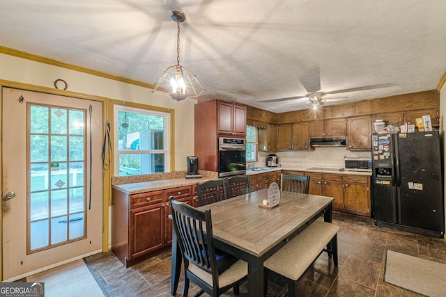 5255 Post Rd, Winston, GA 30187 - kitchen with appliances with stainless steel finishes, light countertops, dark stone finish flooring, under cabinet range hood, and brown cabinetry
