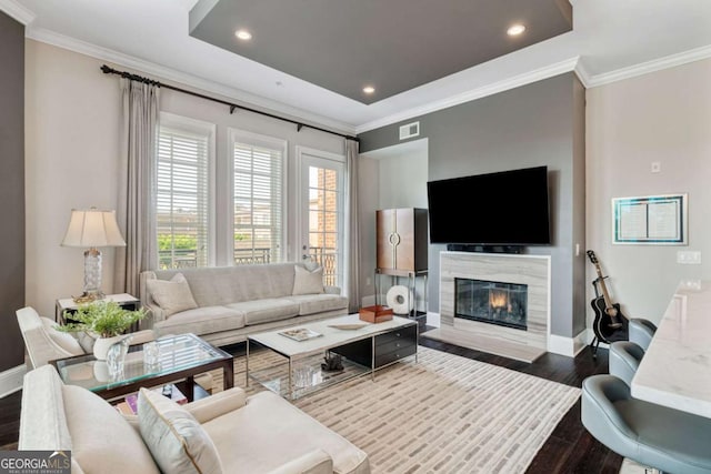 living room with dark wood-style flooring, crown molding, baseboards, a fireplace, and recessed lighting