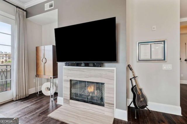 living area with ornamental molding, wood finished floors, baseboards, and a premium fireplace
