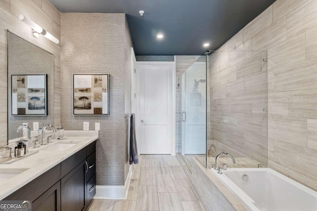 bathroom with a garden tub, a stall shower, double vanity, recessed lighting, and baseboards