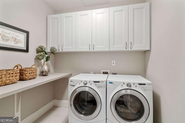 clothes washing area with washer and clothes dryer, cabinet space, and baseboards