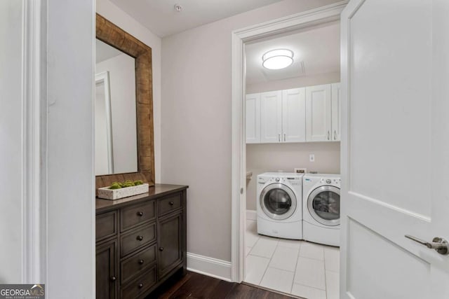 laundry area featuring separate washer and dryer, cabinet space, baseboards, and dark wood-style floors