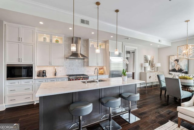 58 Canton St Unit 404, Alpharetta, GA 30009 - kitchen with wall chimney exhaust hood, built in appliances, a sink, ornamental molding, and backsplash