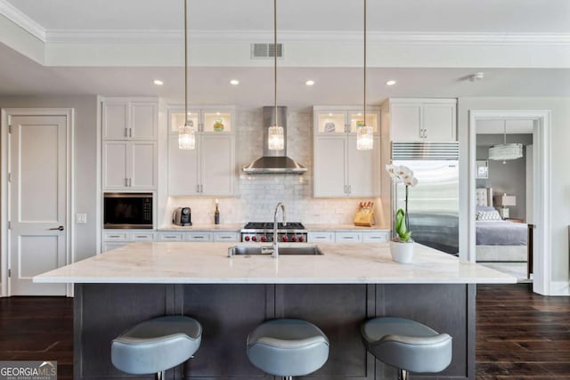 58 Canton St Unit 404, Alpharetta, GA 30009 - kitchen with wall chimney range hood, a sink, built in appliances, white cabinetry, and crown molding