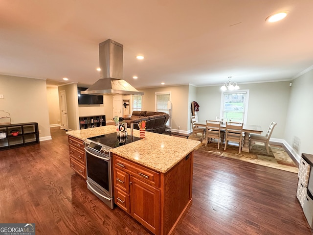 kitchen featuring electric range, island range hood, brown cabinetry, light stone counters, and a kitchen island