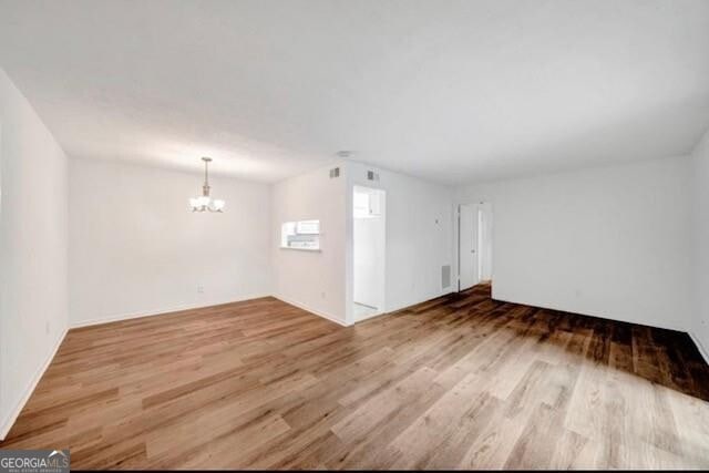 3142 Reeves St SE, Smyrna, GA 30080 - unfurnished living room with a chandelier and wood finished floors