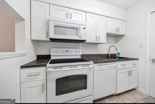 3142 Reeves St SE, Smyrna, GA 30080 - kitchen with white appliances, a sink, white cabinets, dark stone countertops, and light tile patterned floors