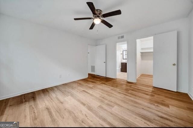 3142 Reeves St SE, Smyrna, GA 30080 - unfurnished bedroom with wood finished floors, a spacious closet, baseboards, and connected bathroom