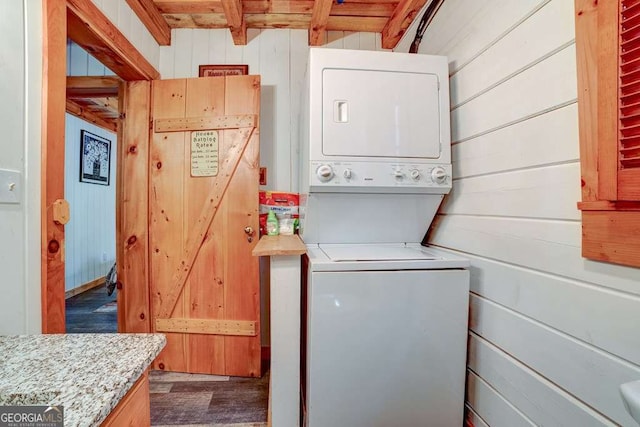 369 Trillium Rd, Suches, GA 30572 - laundry room with stacked washer / dryer, wood walls, and dark wood-type flooring