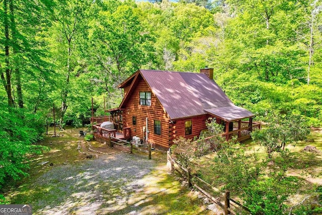 369 Trillium Rd, Suches, GA 30572 - view of property exterior with a deck, log exterior, a chimney, a wooded view, and metal roof